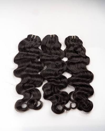 Three dark body-wave hair bundles arranged on a white background.